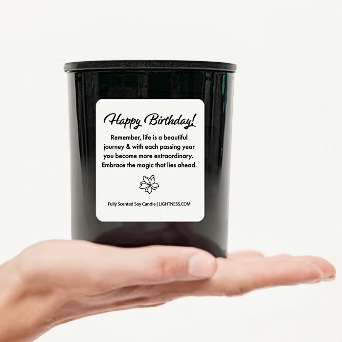 Candle in black glass jar on hand with Birthday quote - Remember, life is a beautiful journey, and with each passing year, you become more extraordinary. Embrace the magic that lies ahead.