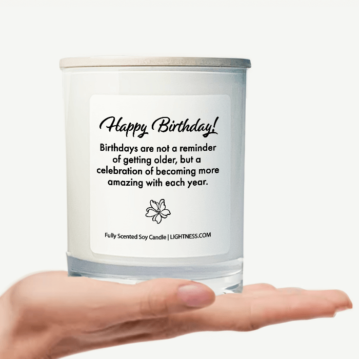 Candle in white glass jar on hand with Birthday quote - Birthdays are not a reminder of getting older, but a celebration of becoming more amazing with each year.