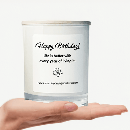 Candle in white glass jar on hand with Birthday quote - Life is better with every year of living it.