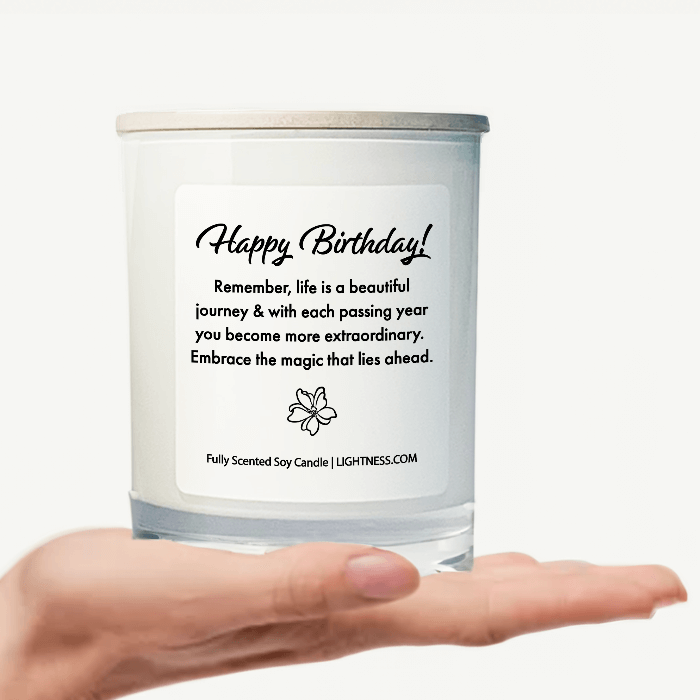 Candle in white glass jar on hand with Birthday quote - Remember, life is a beautiful journey, and with each passing year, you become more extraordinary. Embrace the magic that lies ahead.