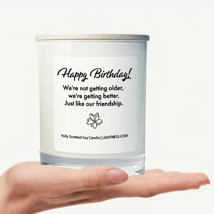 Candle in white glass jar on hand with Birthday quote - We're not getting older, we're getting better. Just like our friendship.