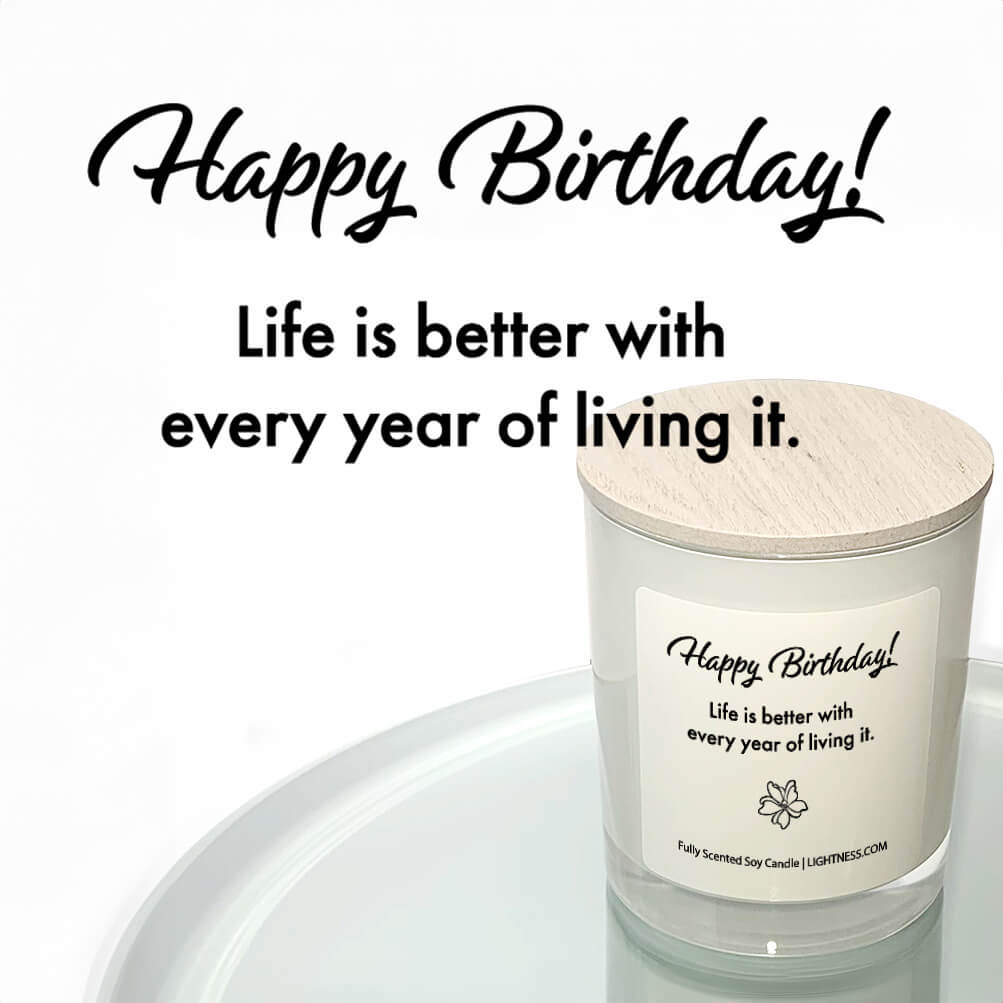 Candle in white glass jar reflected in mirror with Birthday quote - Life is better with every year of living it.