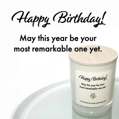 Candle in white glass jar reflected in mirror with Birthday quote - May this year be your most remarkable one yet.