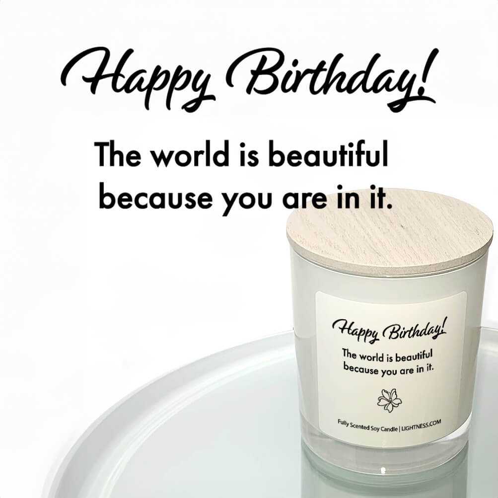 Candle in white glass jar reflected in mirror with Birthday quote - The world is beautiful because you are in it.