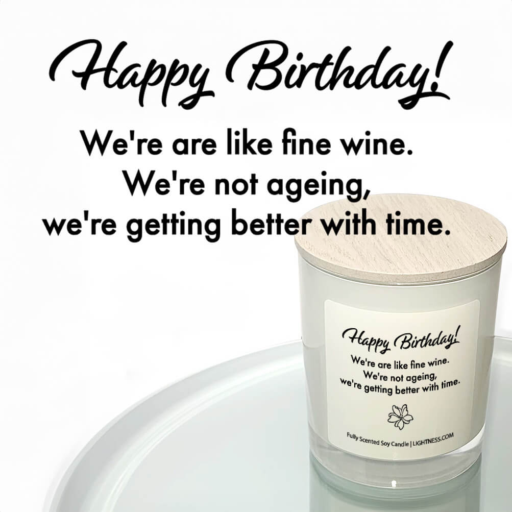 Candle in white glass jar reflected in mirror with birthday quote - Happy Birthday! We're like fine wine. We're getting better with time.