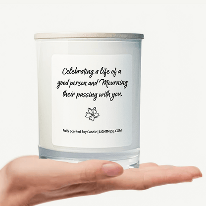 Candle in white glass jar on hand with Condolence quote - Celebrating a life of a good person and mourning their passing with you.