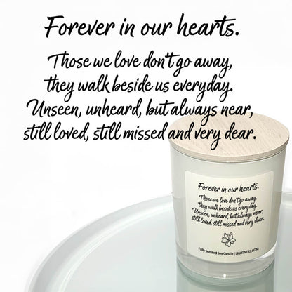 Candle in white glass jar reflected in mirror with Condolence quote - Forever in our hearts. Those we love don't go away, they walk beside us every day. Unseen, unheard, but always near, still loved, still missed and very dear.