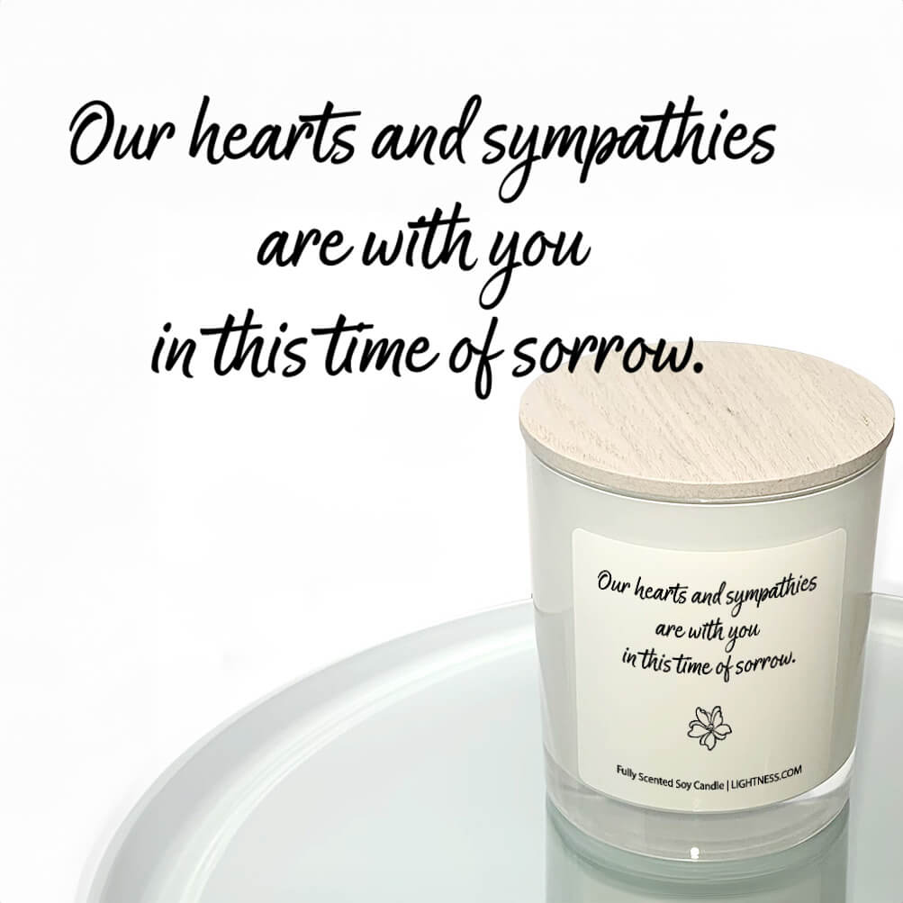 Candle in white glass jar reflected in mirror with Condolence quote - Our hearts are with you in this time of sorrow.