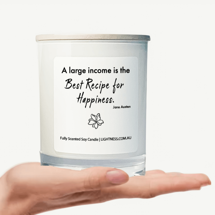 Candle in white glass jar on hand with Happiness quote - A large income is the best recipe for happiness.