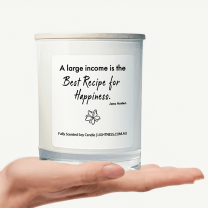 Candle in white glass jar on hand with Happiness quote - A large income is the best recipe for happiness.