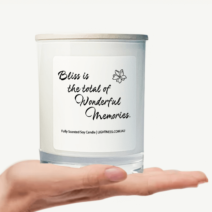 Candle in white glass jar on hand with Happiness quote - Bliss is the total of wonderful memories.