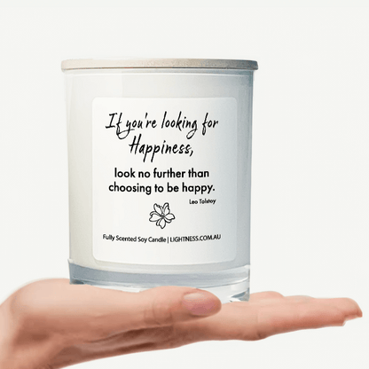 Candle in white glass jar on hand with Happiness quote - If you're looking for happiness, look no further than choosing to be happy.