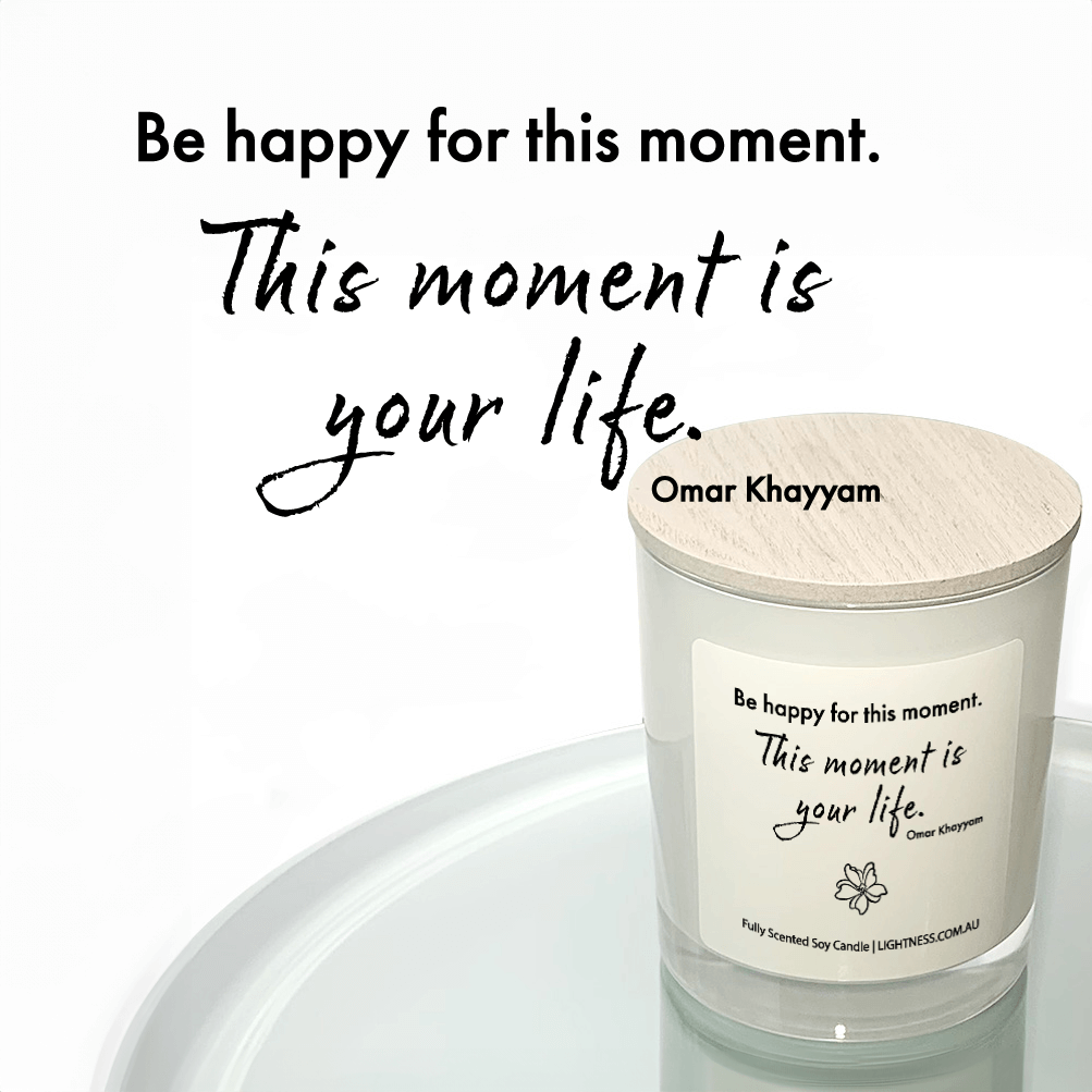 Candle in white glass jar reflected in mirror with Happiness quote - Be happy for this moment. This moment is your life.