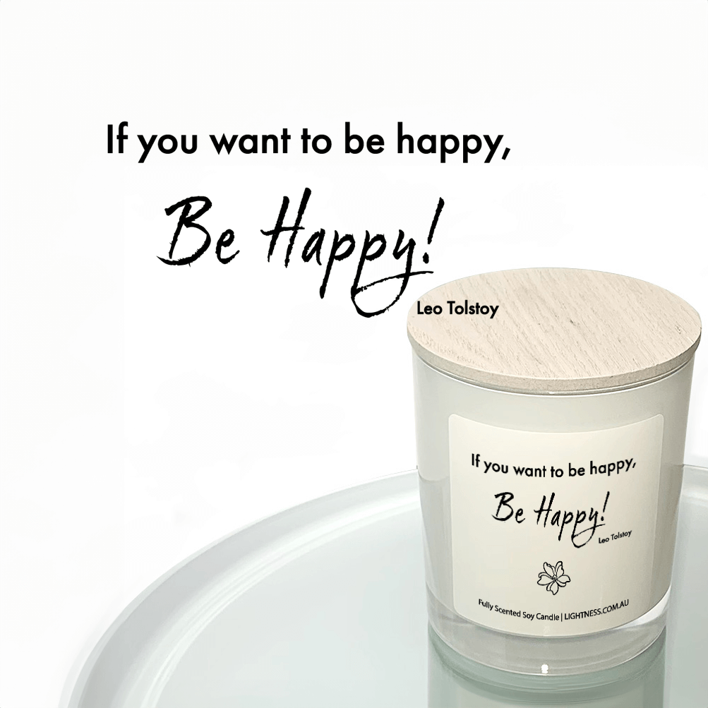 Candle in white glass jar reflected in mirror with Happiness quote - If you want to be happy, be happy.