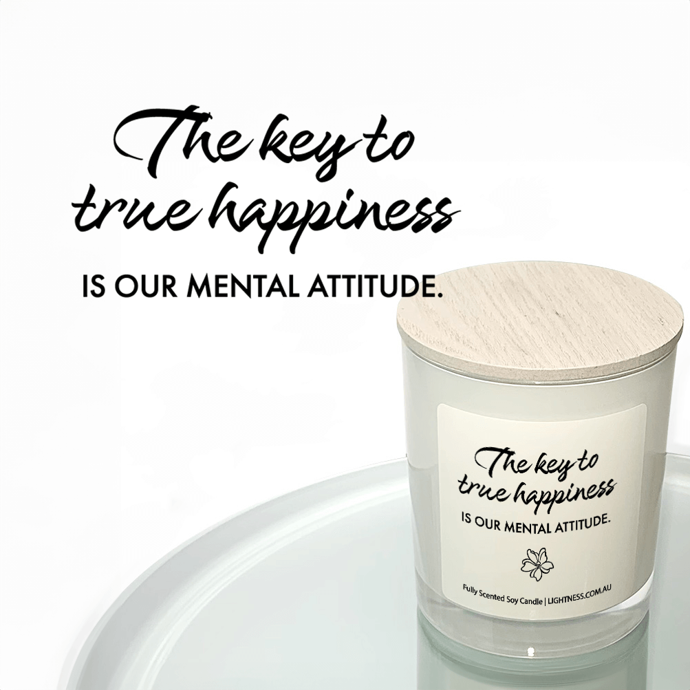 Candle in white glass jar reflected in mirror with Happiness quote - The key to true happiness is our mental attitude.