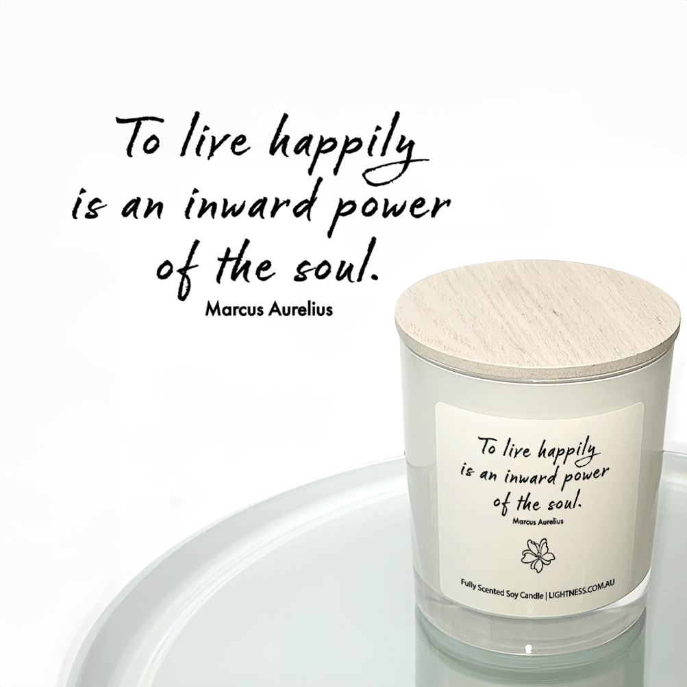 Candle in white glass jar reflected in mirror with Happiness quote - To live happily is an inward power of the soul.