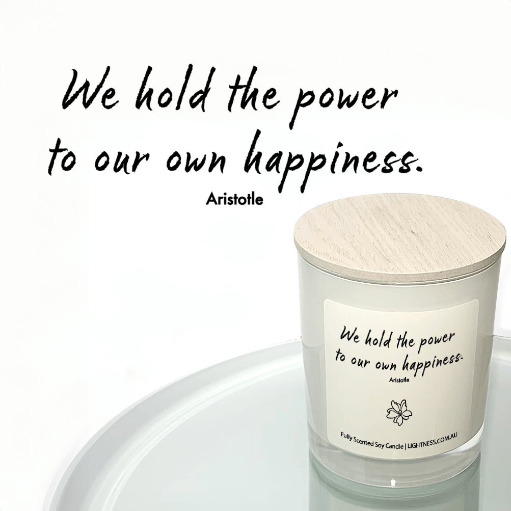 Candle in white glass jar reflected in mirror with Happiness quote - We hold the power to our own happiness.