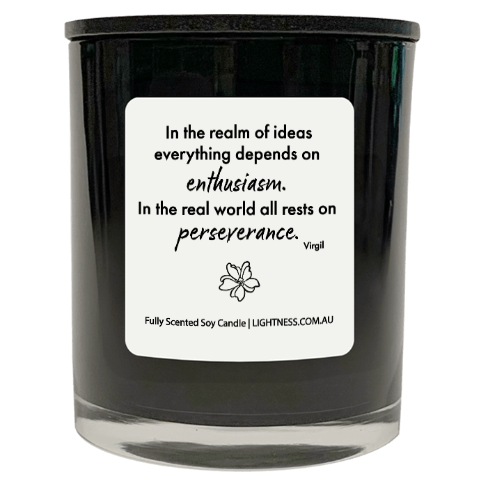 Candle in black glass jar with motivational quote - In the realm of ideas everything depends on enthusiasm. In the real world all rests on perseverance.