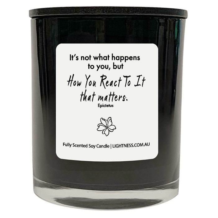 Candle in black glass jar with motivational quote - It's not what happens to you, but how you react to it that matters.