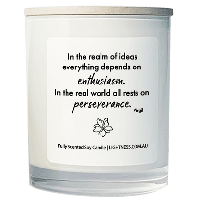 Candle in white glass jar with motivational quote - In the realm of ideas everything depends on enthusiasm. In the real world all rests on perseverance.