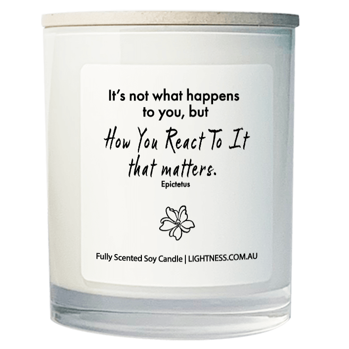 Candle in white glass jar with motivational quote - It's not what happens to you, but how you react to it that matters.