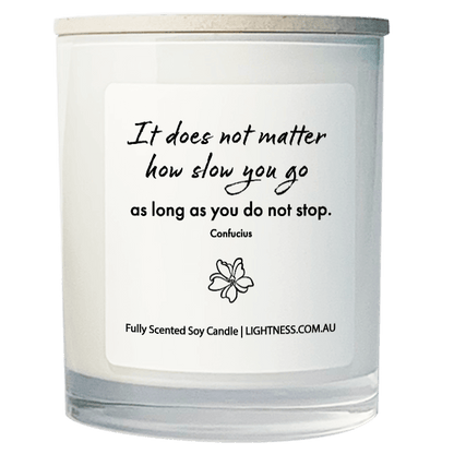 Candle in white glass jar with motivational quote - It does not matter how slow you go as long as you do not stop.