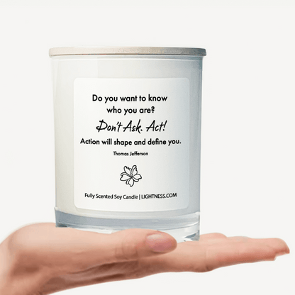 Candle in white glass jar on hand with motivational quote - Do you want to know who you are Don't ask. Act Action will shape and define you.